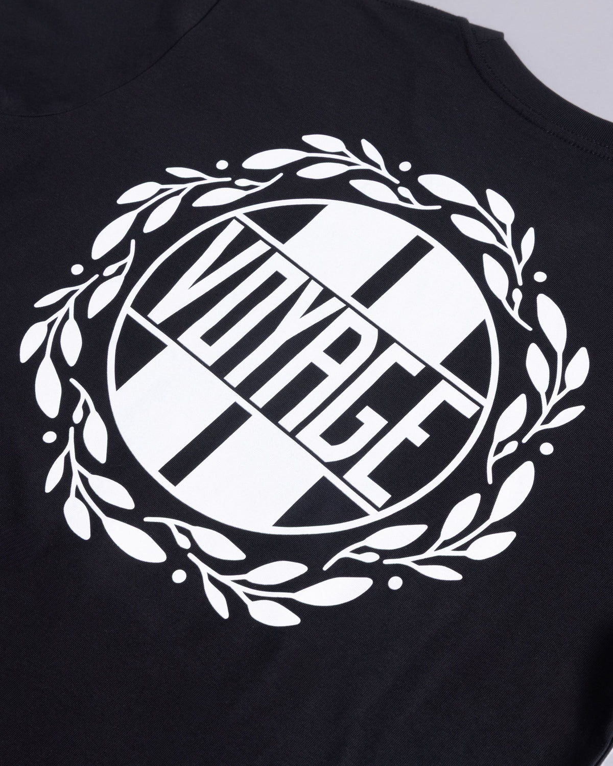 Voyage Emblem Tee Black, close-up detail
